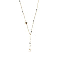 Y-shaped gold-plated necklace with white and gray freshwater pearls on cream background, showing adjustable drop design.