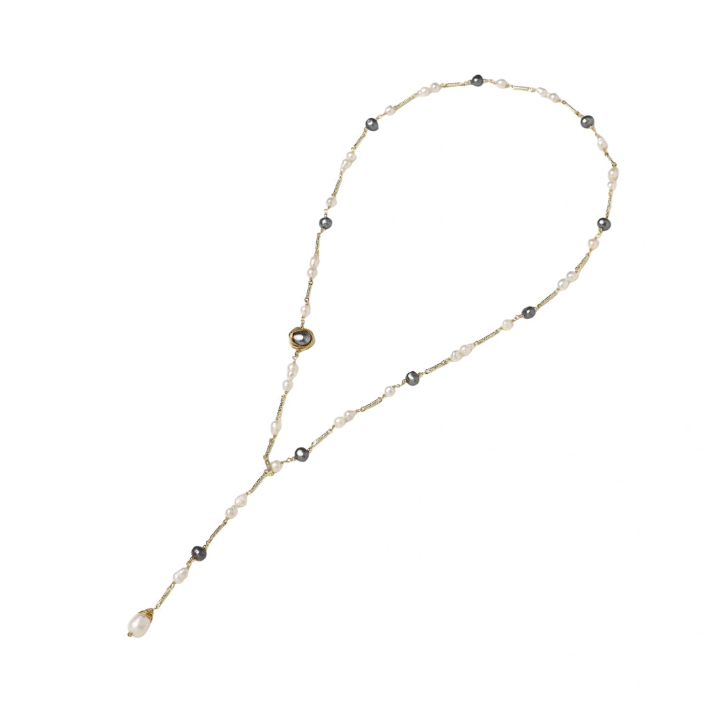 Y-shaped gold-plated necklace with white and gray freshwater pearls on cream background, showing adjustable drop design.