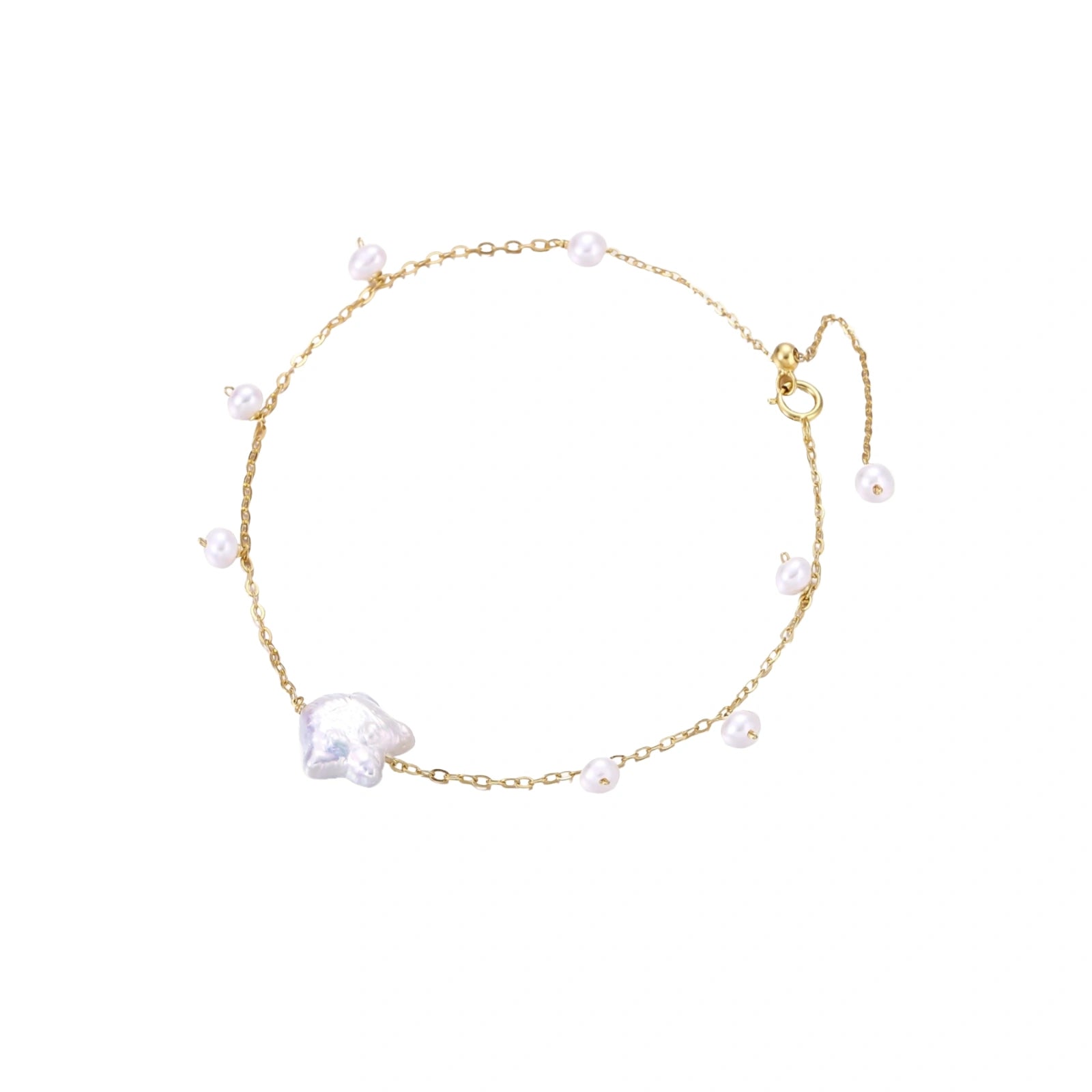 Delicate gold chain bracelet with baroque pearl centerpiece and small freshwater pearls on cream background.