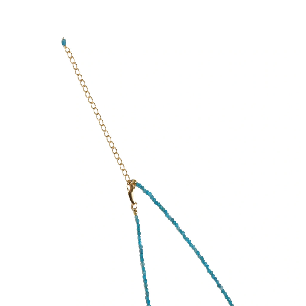 Delicate gold vermeil necklace with teal apatite beads and freshwater pearl on white background.