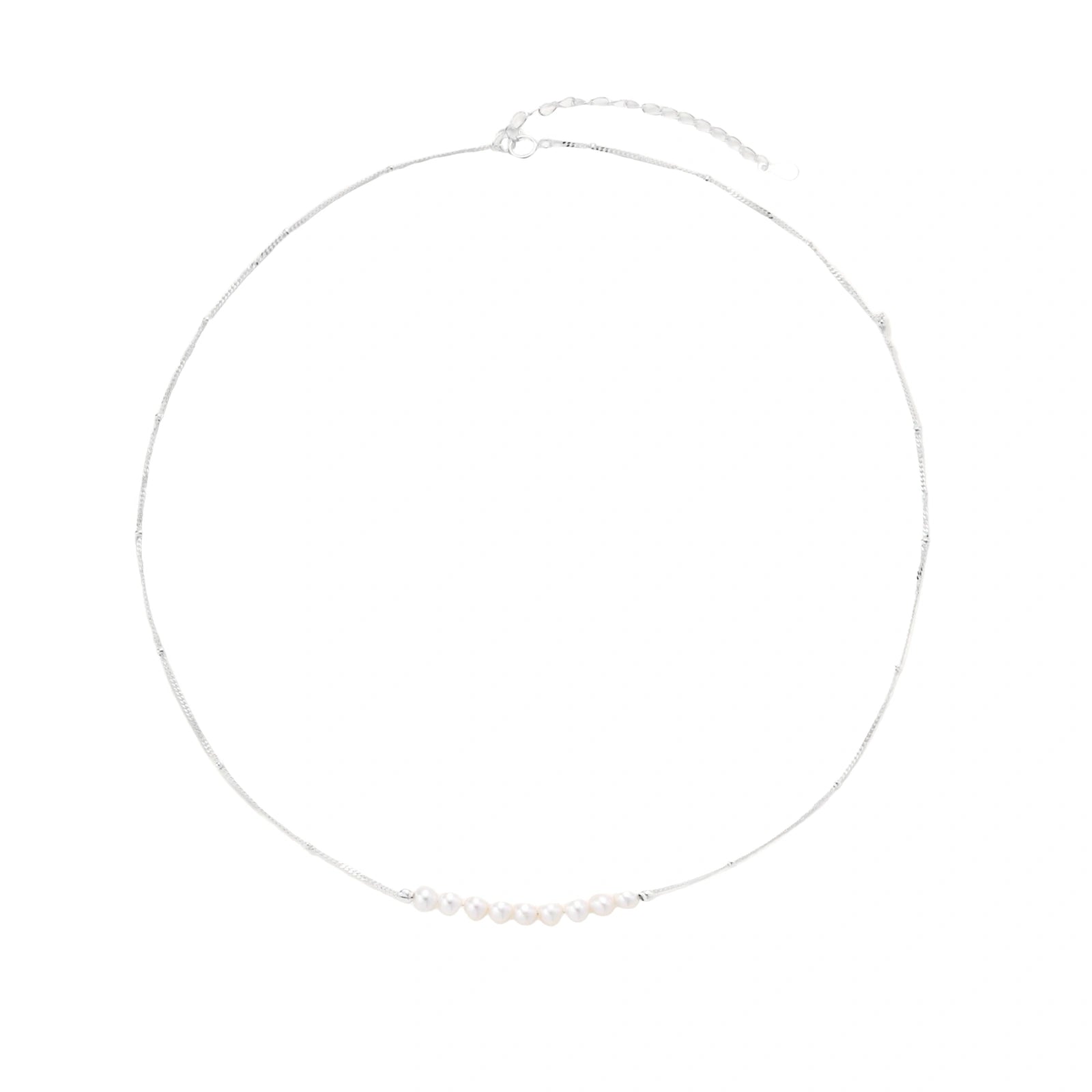 Delicate sterling silver chain necklace with small freshwater pearls arranged in a curved smile arc on cream background.