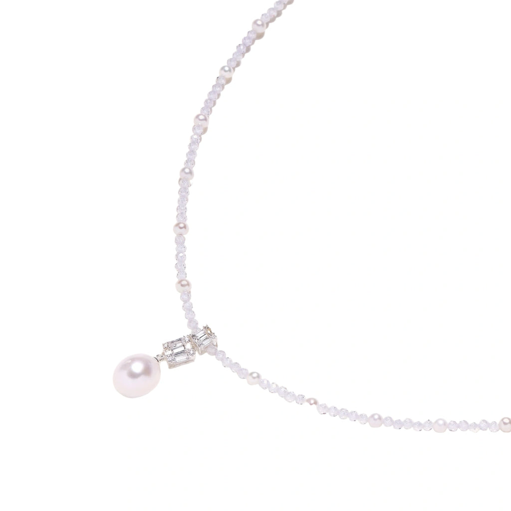 Dainty necklace with lavender crystal beads, freshwater pearls, geometric pendant, and large pearl drop on white background.