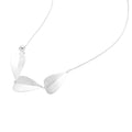 Minimalist sterling silver necklace with three brushed leaf-shaped pendants on delicate chain against white background