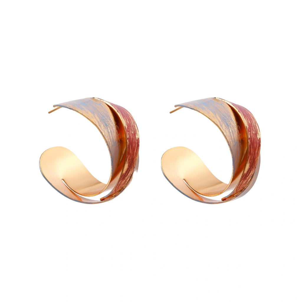 Sculptural gold-plated hoop earrings with diagonal purple and coral enamel stripes in twisted ribbon design