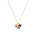 Gold-plated necklace with pink and purple enamel flower pendant featuring crystal accents on cream background