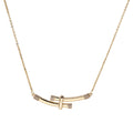 Gold-plated curved bar necklace with diamond accents on delicate chain against cream background