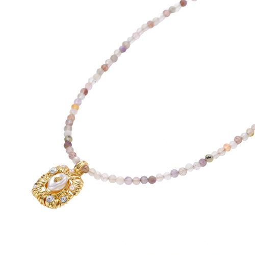 Ornate gold-plated pendant necklace with multicolored gemstone beads in purple, pink and clear tones on white background
