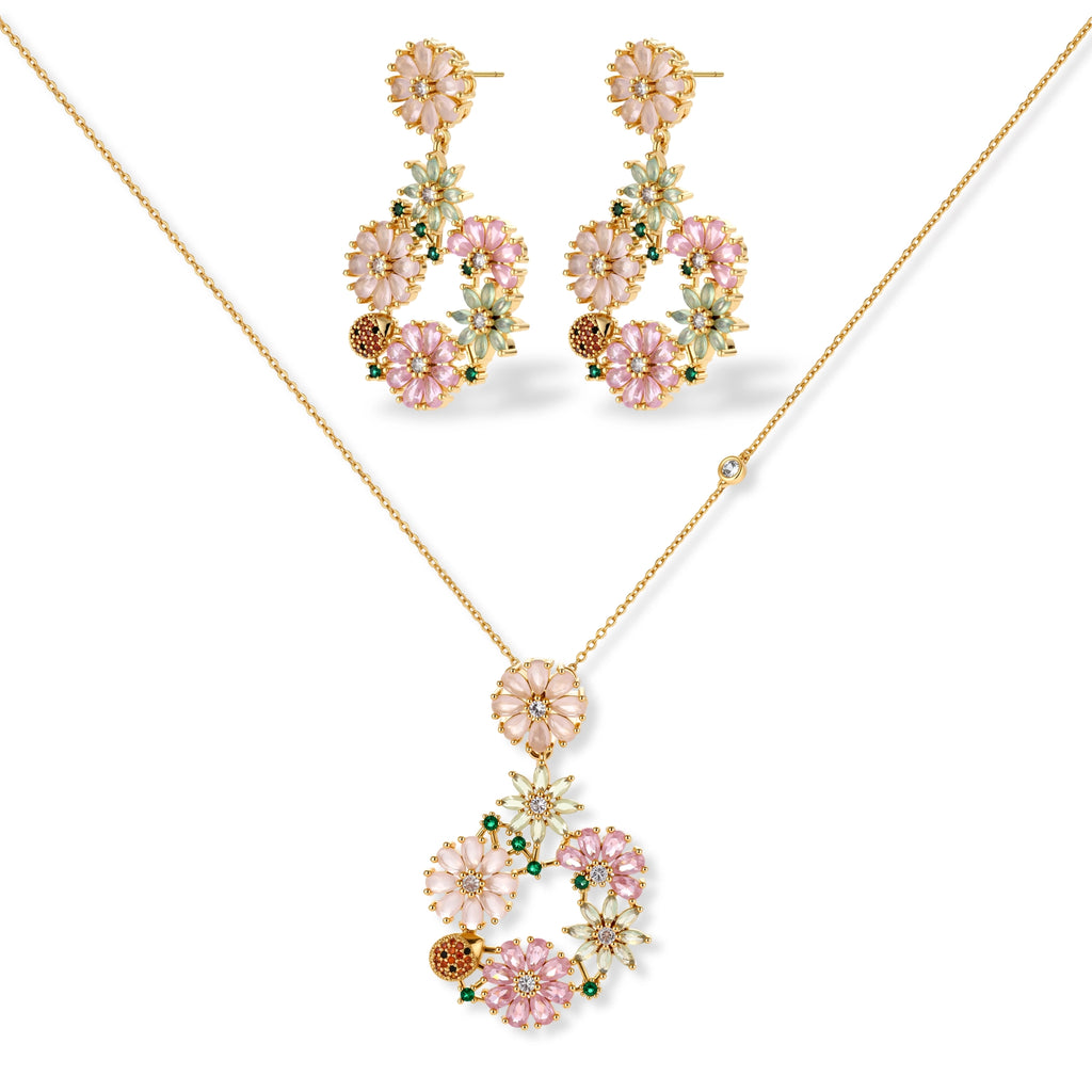 14K gold plated jewelry set with pink and green cubic zirconia flowers arranged in wreath design on cream background