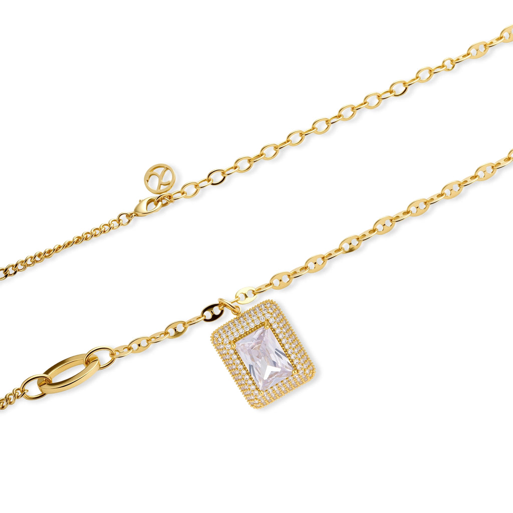 Gold-plated jewelry set with rectangular cubic zirconia stones in pave halo settings on cream background