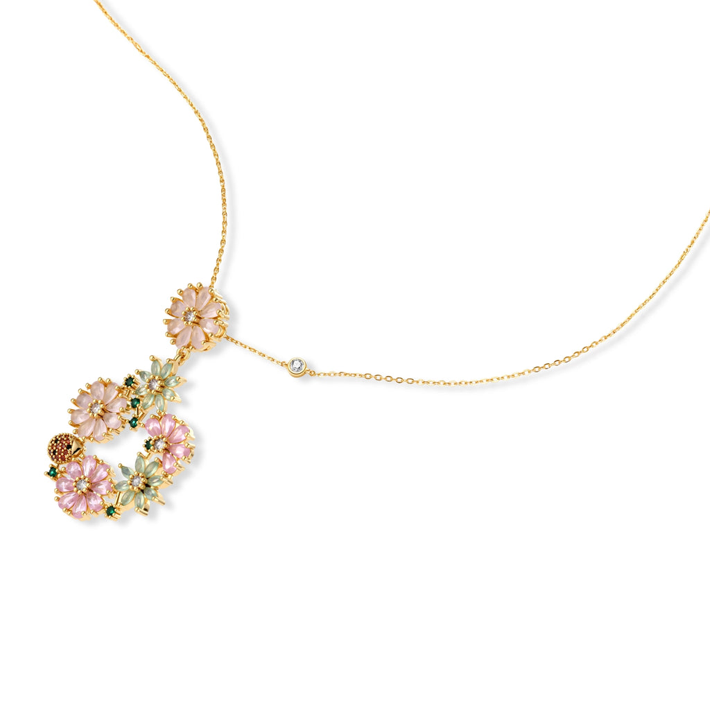 14K gold plated jewelry set with pink and green cubic zirconia flowers arranged in wreath design on cream background